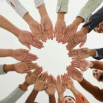 business-employees-joining-hands-to-committ-to-corporate-social-responsibility-704x421